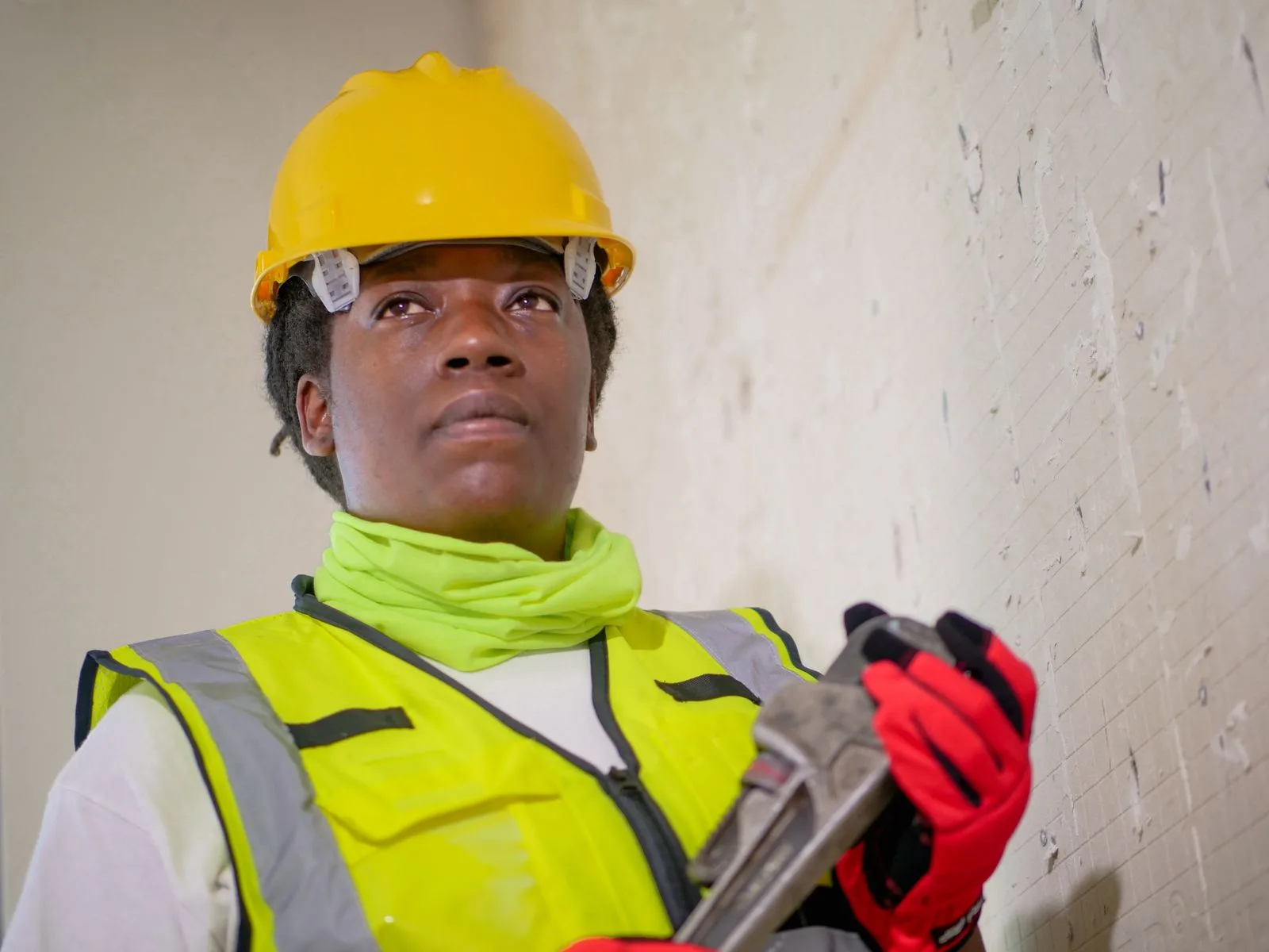 Plumber in safety gear holding a wrench on a sewer line job in Miami