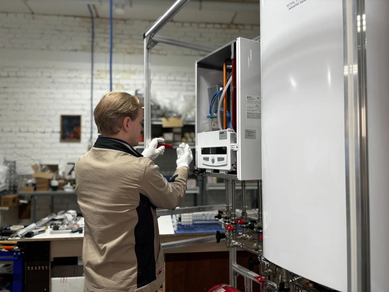 Repair technician using a screwdriver to service an open water heater unit on a water heater repair job in Miami