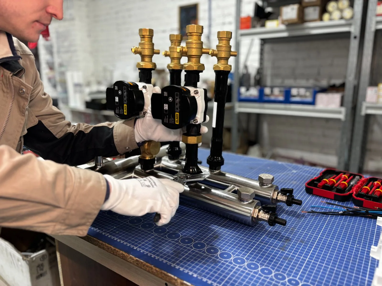 Technician assembling heating system valves and pipe components with hand tools for a water heater repair job in Miami